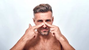 homem tocando no nariz rinoplastia