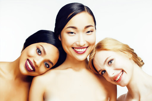 três mulheres sorrindo uma loira uma asiática e uma negra tipos de nariz