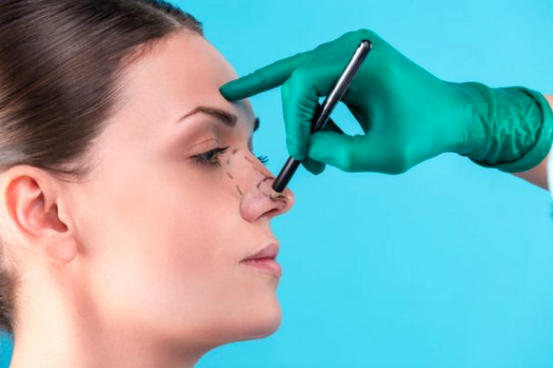 mão de médico apontando nariz de paciente de rinoplastia
