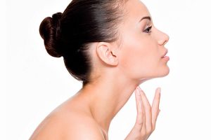 Mulher de perfil tocando o pescoço demonstrando benefícios de rinoplastia e Lipoaspiração de Pescoço
