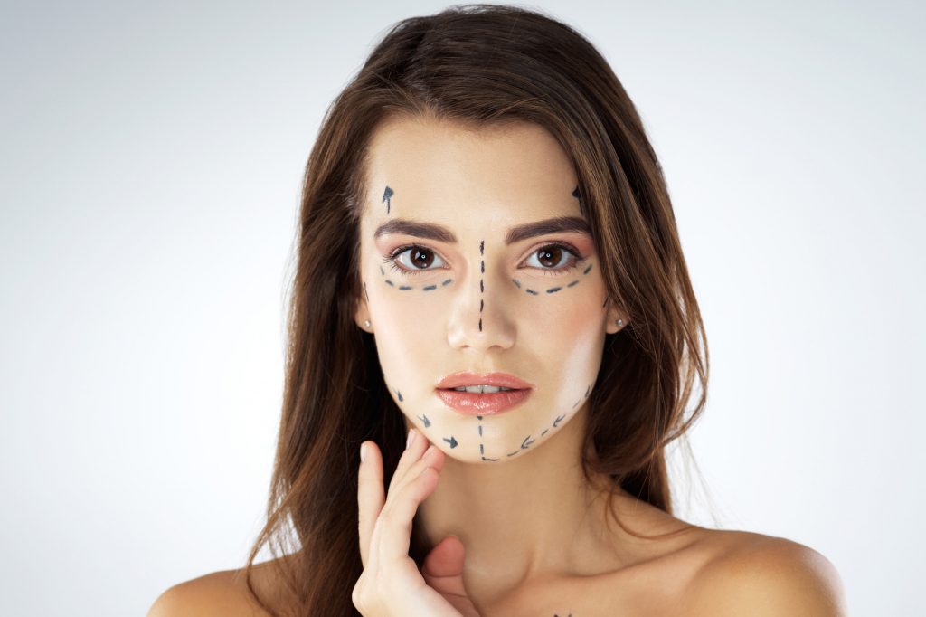 Mulher com rosto desenhado para cirurgias plásticas faciais