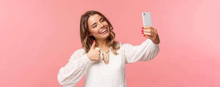 moça bonita sorrindo e olhando para o celular