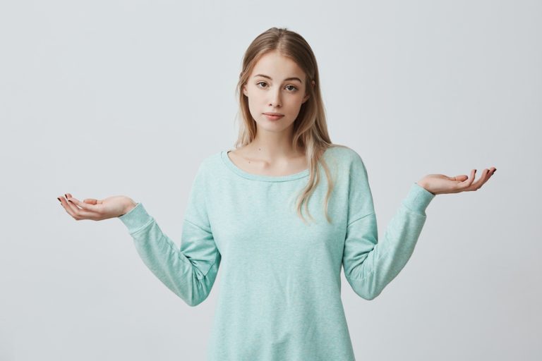 moca-bonita--pensando-de-blusa-azul-mao-no-queixo-pensando-em-alguma-questao-cabelos-aloirados-longos - Qual o Preço de uma Rinoplastia?