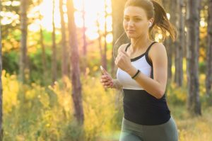 moça bonita caminhando vista de semi perfil cabelo preso roupa fitness - o sol no pós operatório de rinoplastia
