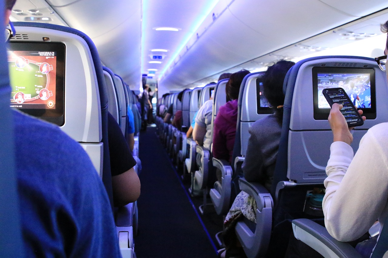 Como planejar minha Rinoplastia morando fora do Brasil? pessoas no avião sentadas usando celular