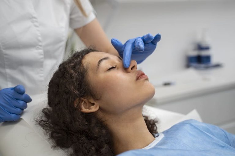 O que Fazer no Pós-Operatório Imediato de Rinoplastia: Guia Completo - mãos de médico com luvas tocando nariz de paciente de rinoplastia