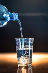 agua saindo de garrafa par copo - A Importância da Hidratação no Pós-Operatório da Rinoplastia