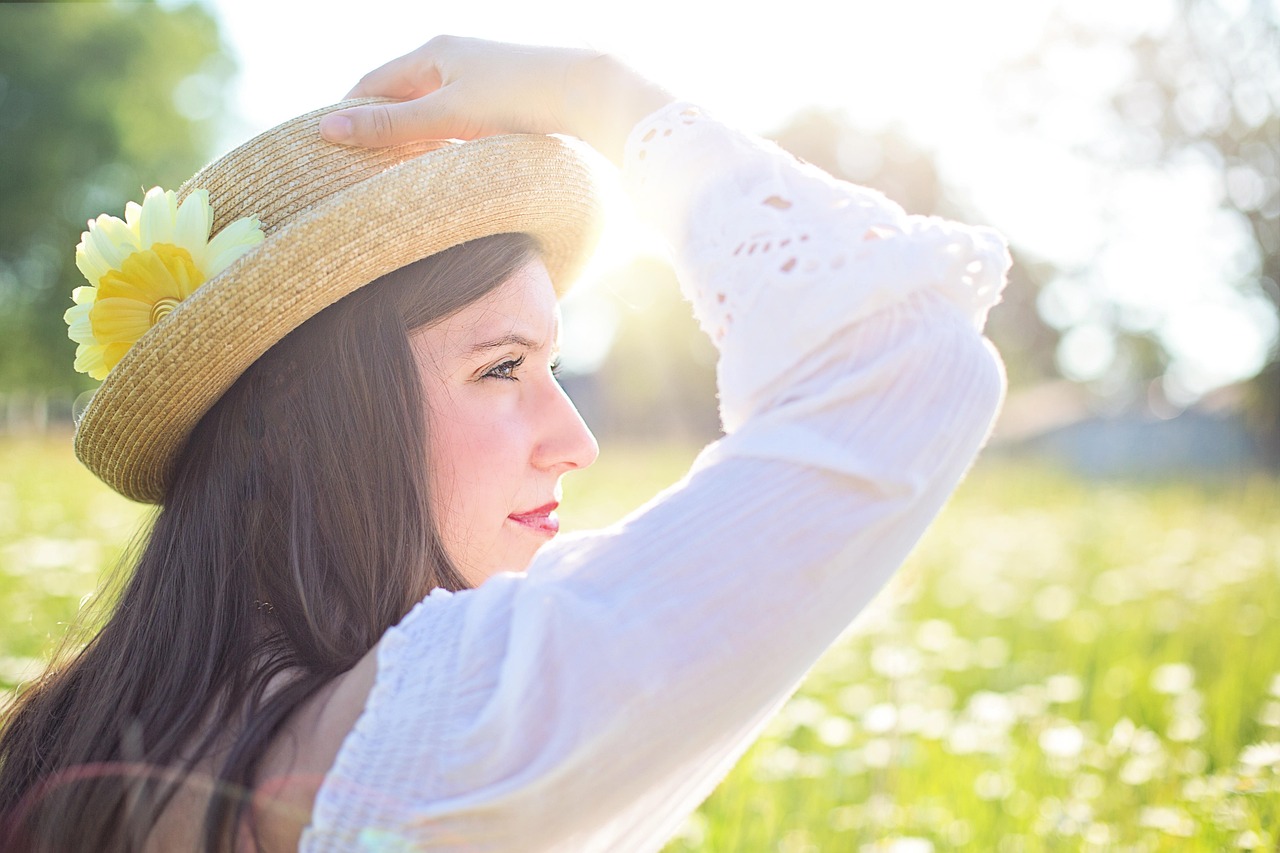moca-bonita-de-perfil-e-chapeu-em-um-lugar-ensolarado-Por-que-nao-posso-tomar-sol-apos-a-rinoplastia-Entenda-os-riscos-e-cuidados
